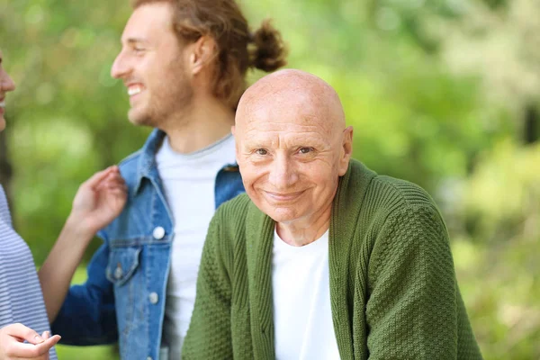 Uomo anziano con parenti nel parco — Foto Stock