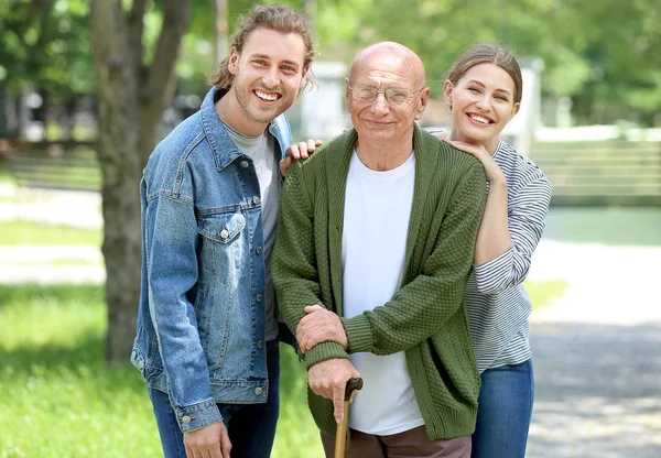 Idős férfi rokonaival a parkban — Stock Fotó