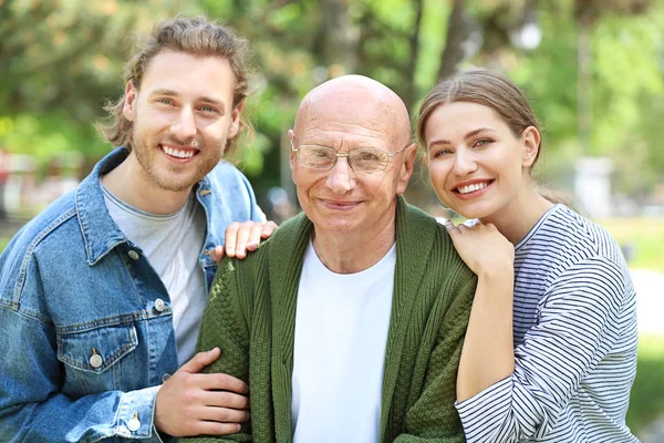 Uomo anziano con i suoi parenti nel parco — Foto Stock