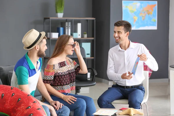 Male travel agent working with young couple in office — Stock Photo, Image