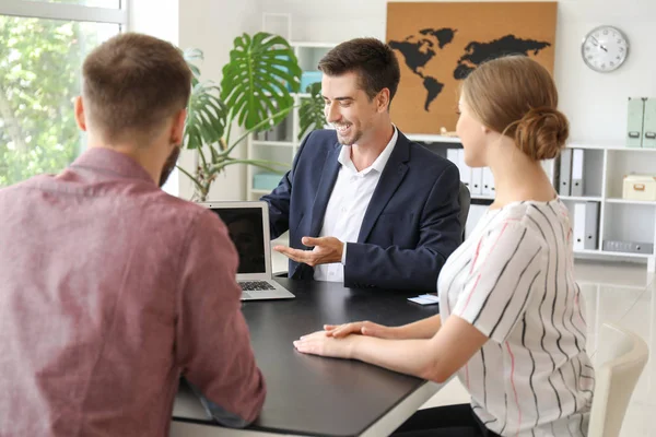 Male travel agent working with young couple in office — Stock Photo, Image