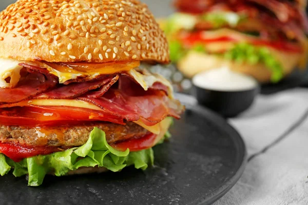 Smaczny Burger z boczkiem na talerzu, zbliżenie — Zdjęcie stockowe