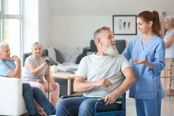 Elderly man with caregiver in nursing home — Stock Photo, Image