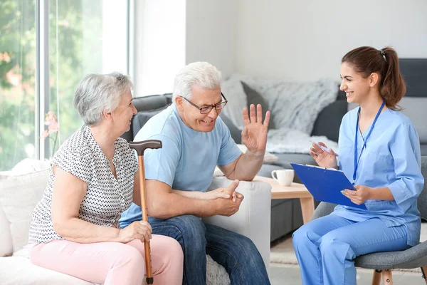 Elderly couple with caregiver in nursing home — Stock Photo, Image