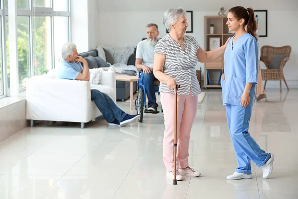 Elderly woman with caregiver in nursing home — Stock Photo, Image