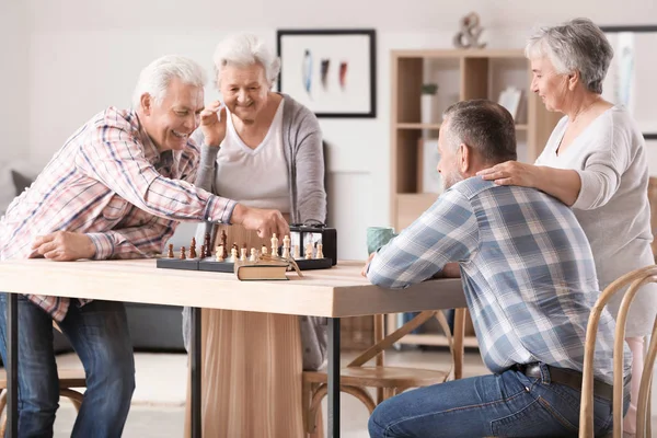 Äldre personer som spelar schack i vårdhem — Stockfoto