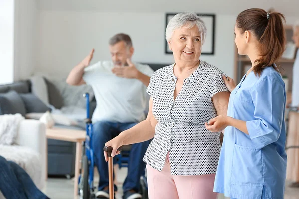 Elderly woman with caregiver in nursing home — Stock Photo, Image