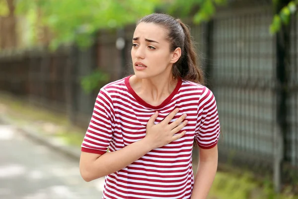 Молодая женщина страдает от сердечного приступа на улице — стоковое фото