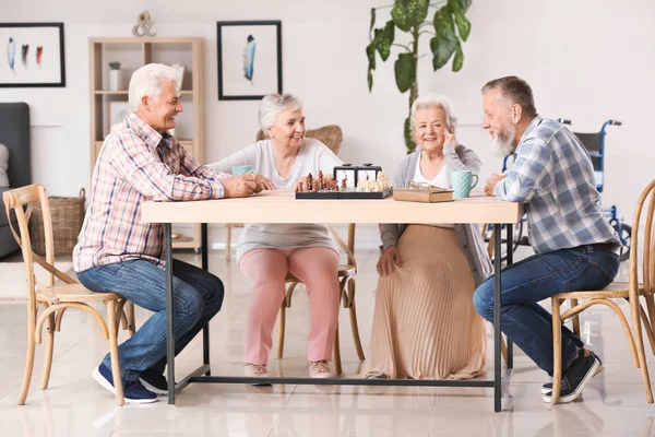 Elderly people playing chess in nursing home — Stock Photo, Image