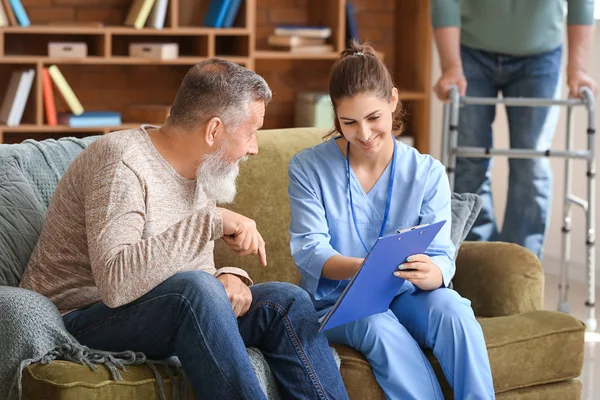 Elderly man with caregiver in nursing home — Stock Photo, Image