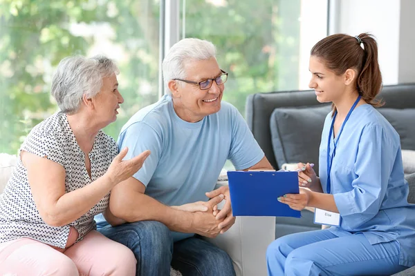 Elderly couple with caregiver in nursing home — Stock Photo, Image