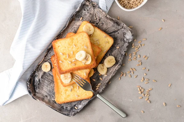 Plate with tasty French toasts and banana on grey table — Stock Photo, Image