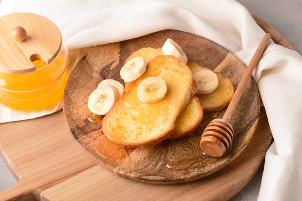 Plate with tasty French toasts, honey and banana on table — Stock Photo, Image