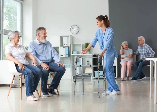 Elderly people with caregiver in nursing home — Stock Photo, Image