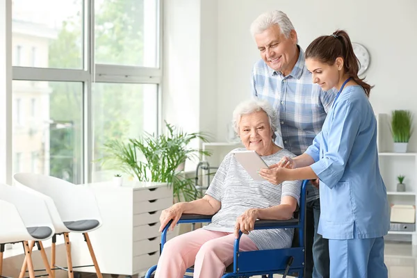 Elderly people with caregiver in nursing home — Stock Photo, Image
