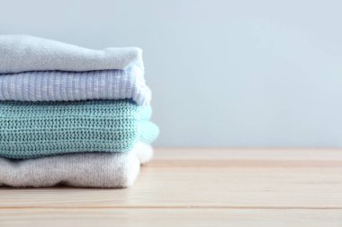 Hafif arka plana karşı masada sıcak giysi yığını