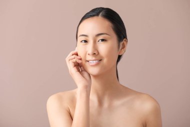 Renkli arka plan üzerinde makyaj uygulamadan önce Asyalı kadın