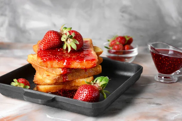 Frying pan with tasty French toasts and strawberry on grey table — Stock Photo, Image