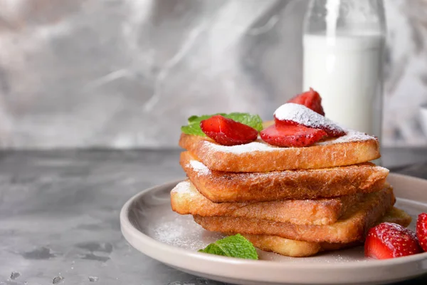 Plate with tasty French toasts and strawberry on grey table — Stock Photo, Image