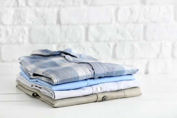 Stack of shirts on white table — Stock Photo, Image