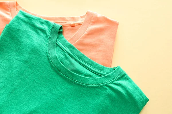 Different t-shirts on color background — Stock Photo, Image