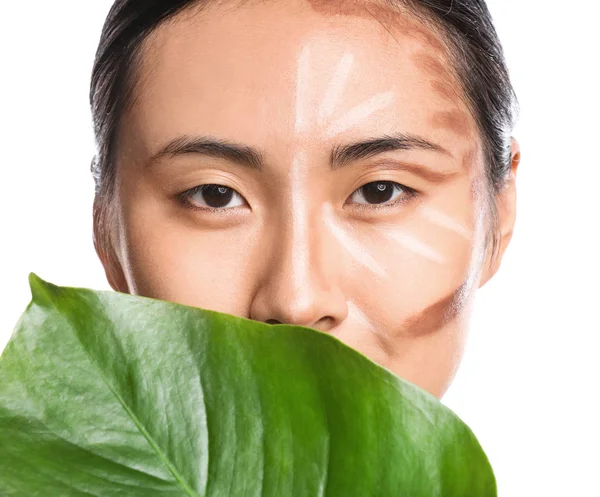 Asiatisk kvinna med contouring makeup och tropiska löv på vit bakgrund — Stockfoto