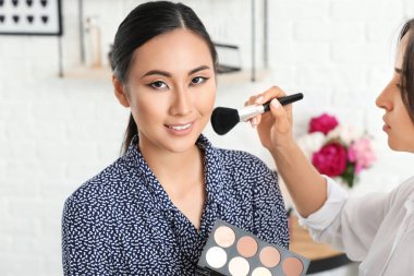 Makyaj sanatçısı güzellik salonunda Asya modeli ile çalışıyor