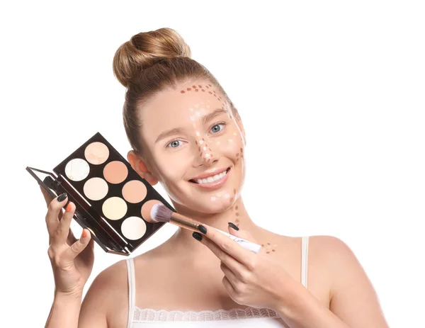Ung kvinna med kosmetika för contouring makeup på vit bakgrund — Stockfoto