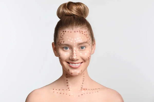 Ung kvinna med contouring makeup på ljus bakgrund — Stockfoto