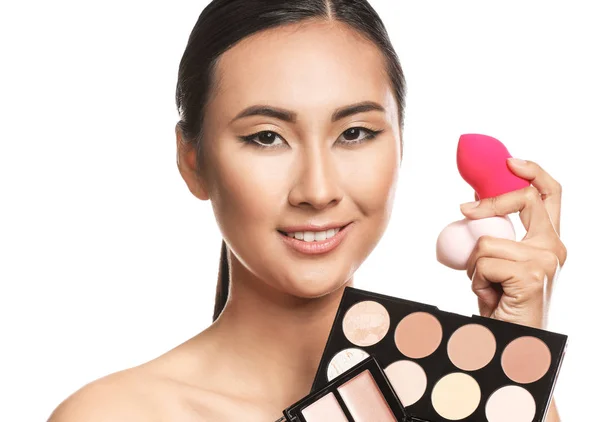 Mujer asiática con cosméticos para contornear maquillaje sobre fondo blanco —  Fotos de Stock