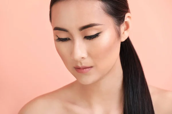 Asian woman with beautiful makeup on color background
