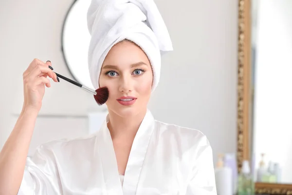 Beautiful young woman applying makeup at home — Stock Photo, Image