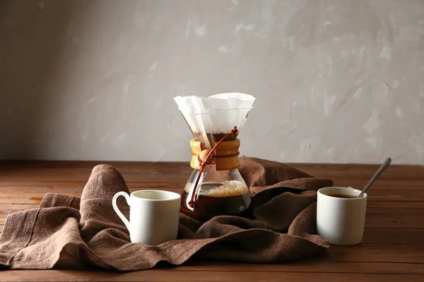 Café saboroso em chemex e xícaras em mesa de madeira — Fotografia de Stock