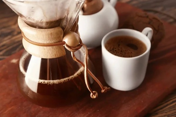 Café saboroso em chemex e xícara na placa de madeira — Fotografia de Stock