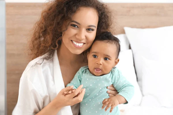 Happy African-American mother with cute little baby in bedroom — Stock Photo, Image