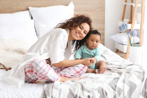 Feliz madre afroamericana con lindo bebé en el dormitorio — Foto de Stock