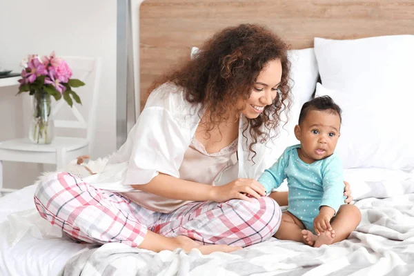 Happy афро-американської матері з милою маленькою дитиною в спальні — стокове фото