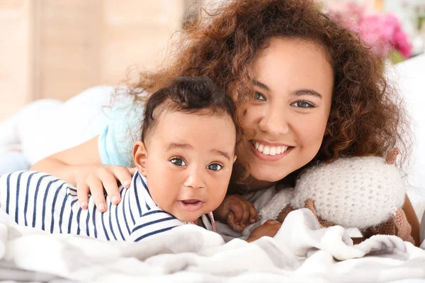 Happy афро-американської матері з милою маленькою дитиною в спальні — стокове фото