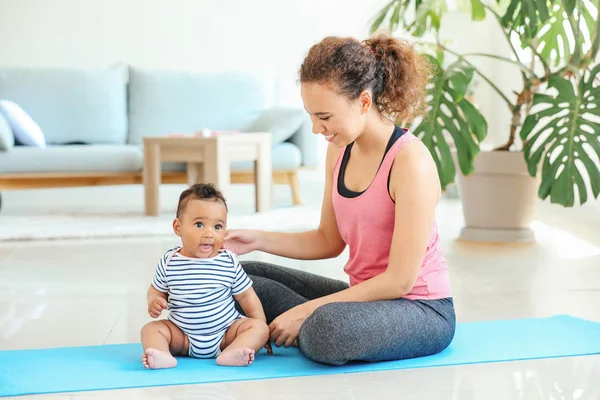 African-American mother training with cute little baby at home — Stock Photo, Image