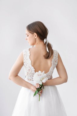 Hafif arka plan üzerinde güzel şakayık ile genç gelin, arka görünüm