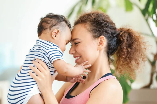 Afro-americana madre entrenamiento con lindo pequeño bebé en casa — Foto de Stock