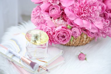 Kitap, parfüm şişesi ve makyaj fırçaları ile güzel şakayık