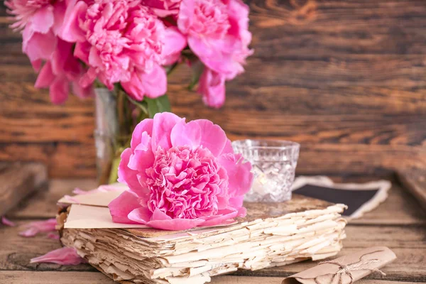 Old book with beautiful peony on wooden table — Stock Photo, Image