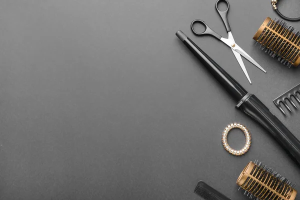 Набор инструментов и аксессуаров для парикмахеров на тёмном фоне — стоковое фото