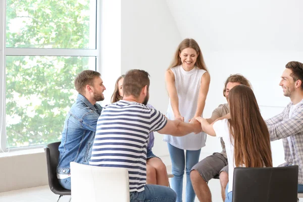 Jóvenes tomados de la mano en la sesión de terapia de grupo — Foto de Stock