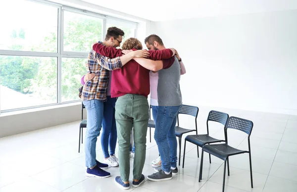 Young people hugging together at group therapy session — Stock Photo, Image