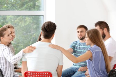 Grup terapi seansında gençleri sakinleştiren insanlar