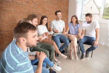 Genç insanlar grup terapisi oturumunda el tutuyorlar