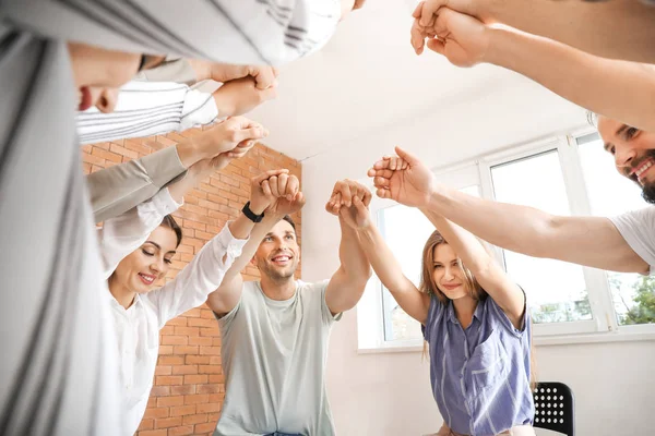 Jonge mensen die handen bij elkaar houden tijdens groepstherapie sessie — Stockfoto