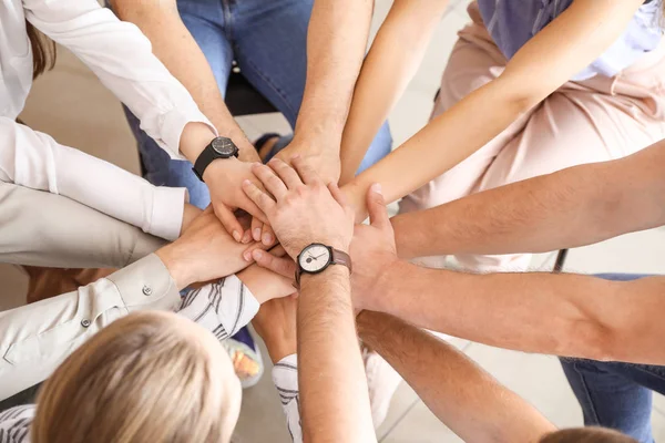 Jóvenes poniendo manos juntas en la sesión de terapia de grupo —  Fotos de Stock